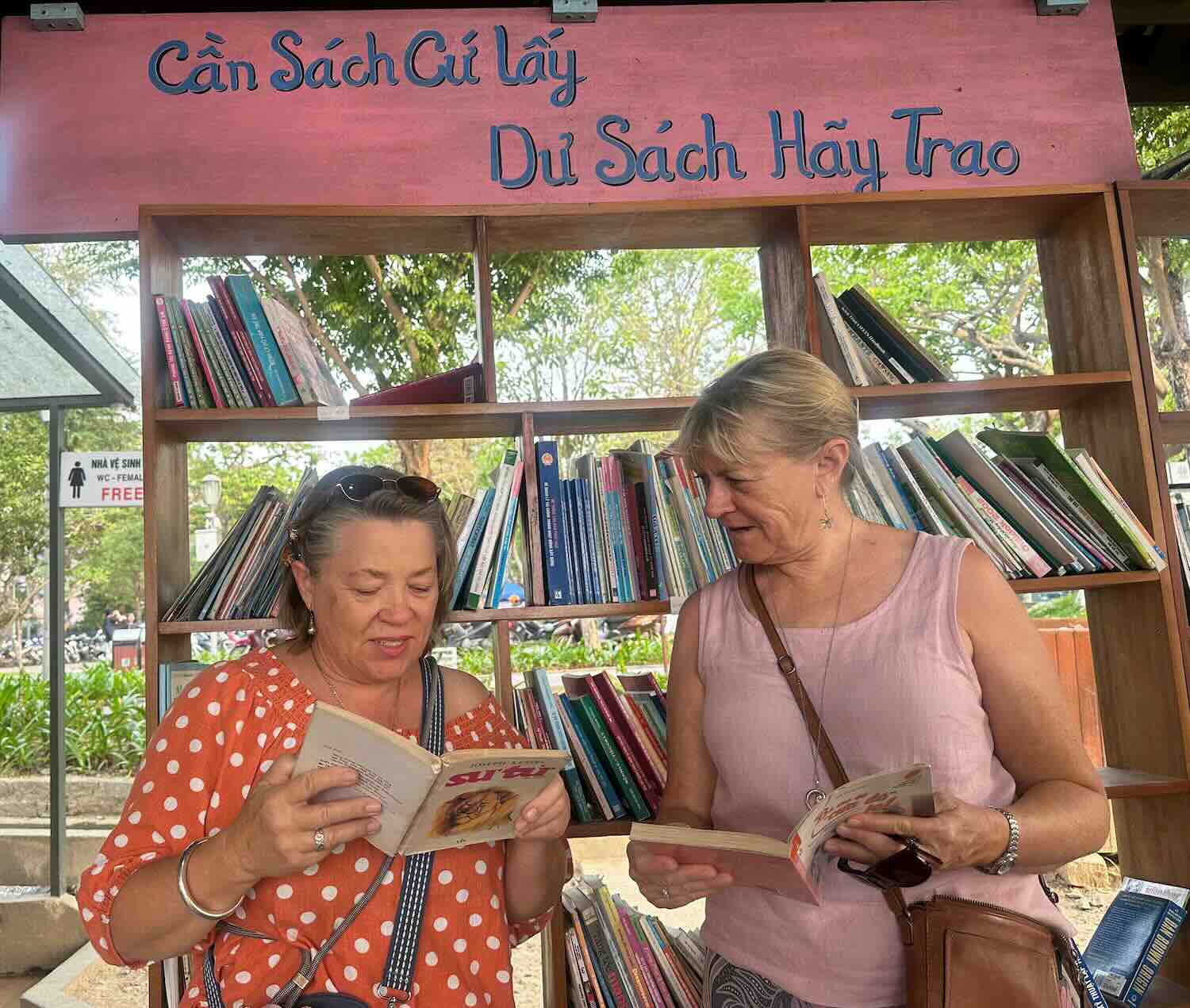 Foreign tourists excitedly read books by the Perfume River. Photo: Ngo Hien.