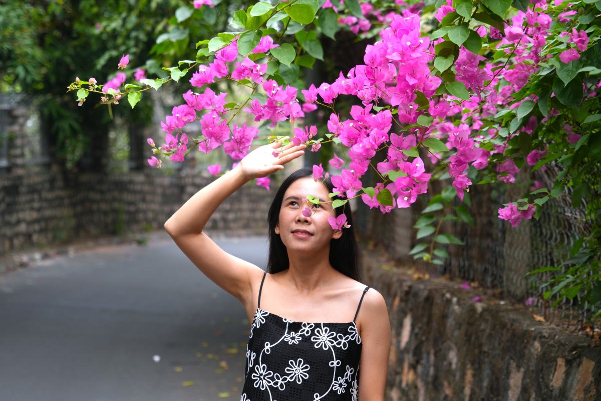 Du khách check-in cùng hoa giấy trên tuyến đường Hải Đăng dẫn lên đỉnh núi Nhỏ. Ảnh: Thành An