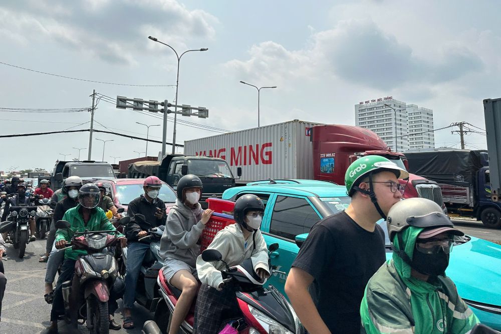 Việc ùn tắc trên làn ôtô cũng khiến hàng loạt xe máy lưu thông ở làn hỗn hợp gặp khó khăn. Nhiều người dân chật vật luồn lách qua các khoảng hở giữa những “hung thần” container, tiềm ẩn nhiều nguy cơ mất an toàn giao thông nghiêm trọng.