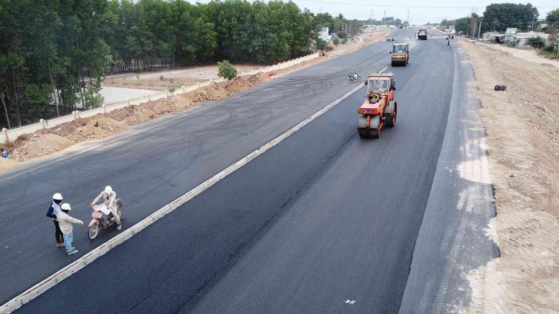 Nhà thầu đang khẩn trương hoàn thiện các hạng mục giao thông cuối cùng như lắp tôn hộ lan, dải phân cách, lưới chống chói, sơn vạch kẻ đường, hệ thống an toàn giao thông, làm bê tông lề đường. Ảnh: HAC