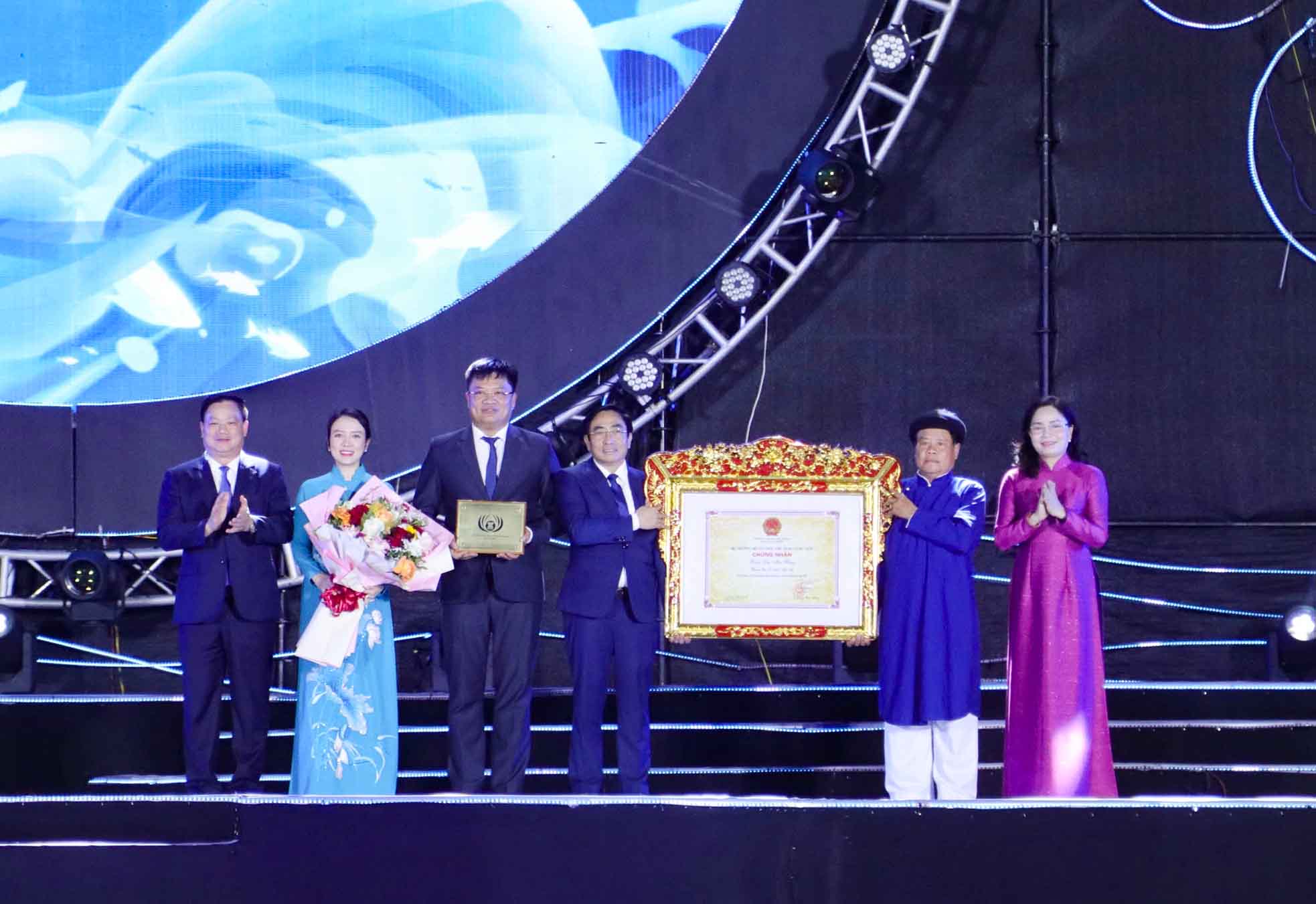 Bà Trịnh Thị Thủy - Thứ trưởng Bộ Văn hóa, Thể thao và Du lịch trao quyết định đưa Lễ hội Đền Mai Bảng vào Danh mục Di sản văn hóa phi vật thể quốc gia cho lãnh đạo Sở Văn hóa, Thể thao và Du lịch Nghệ An và phường Cửa Lò. Ảnh: Duy Chương