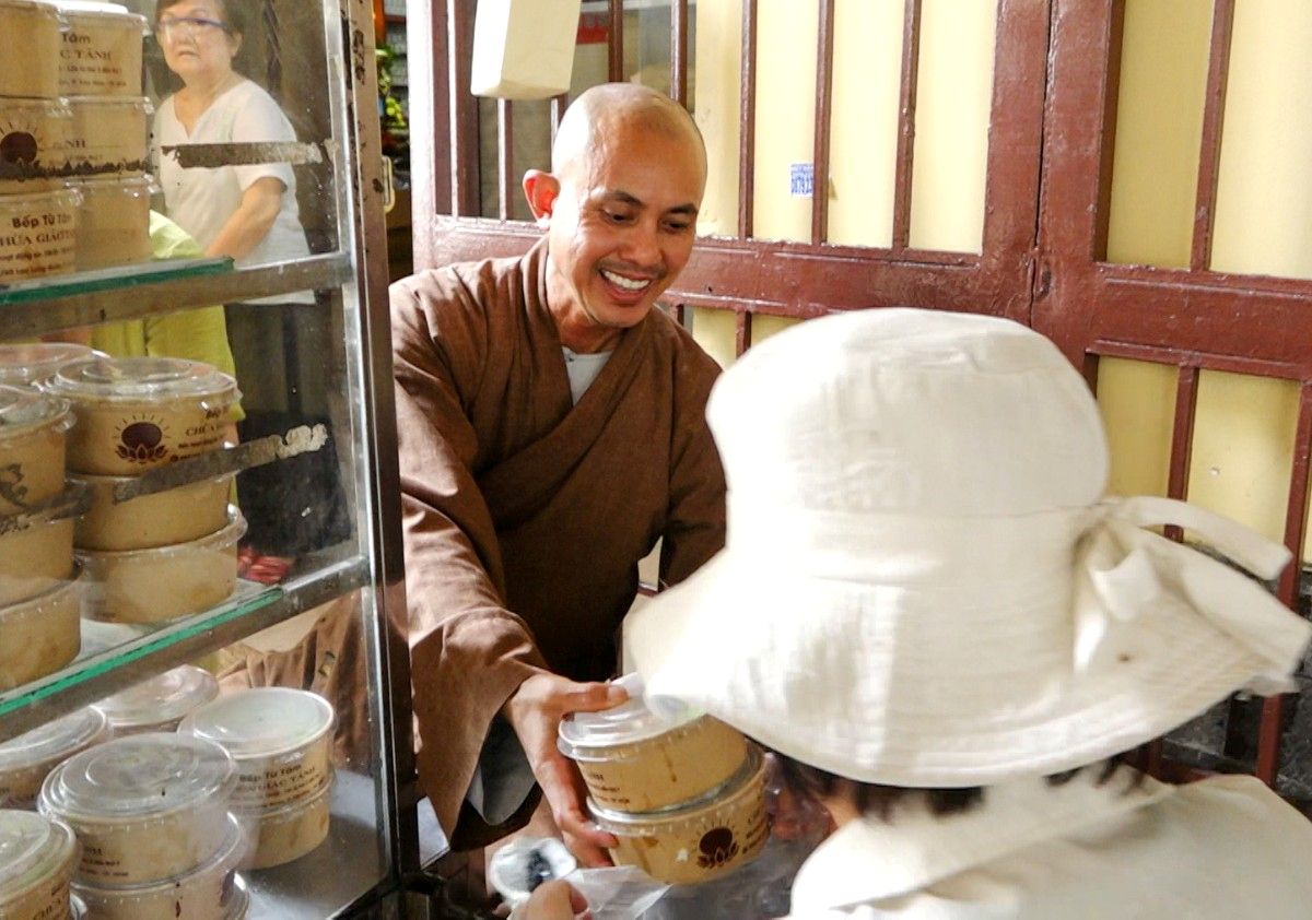 Đại đức Thích Trí Lực - Trụ trì chùa Giác Tánh phát cơm chay miễn phí cho người dân có hoàn cảnh khó khăn. Ảnh: Công Minh