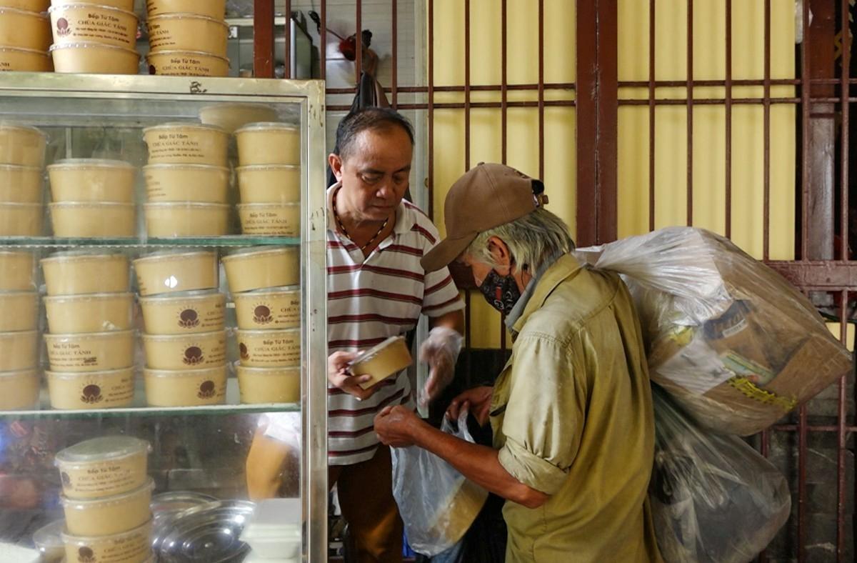 Người dân xếp hàng dài để chờ nhận cơm. Ảnh: Công Minh