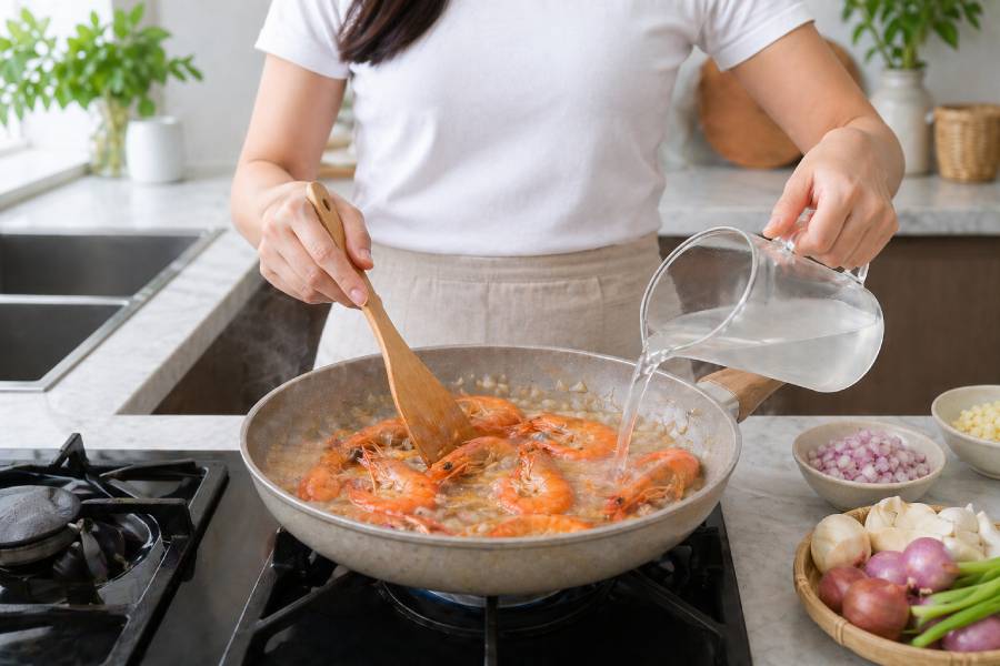 Đổ nước dừa vào sau khi tôm đã săn lại. Ảnh: Thùy Linh. 