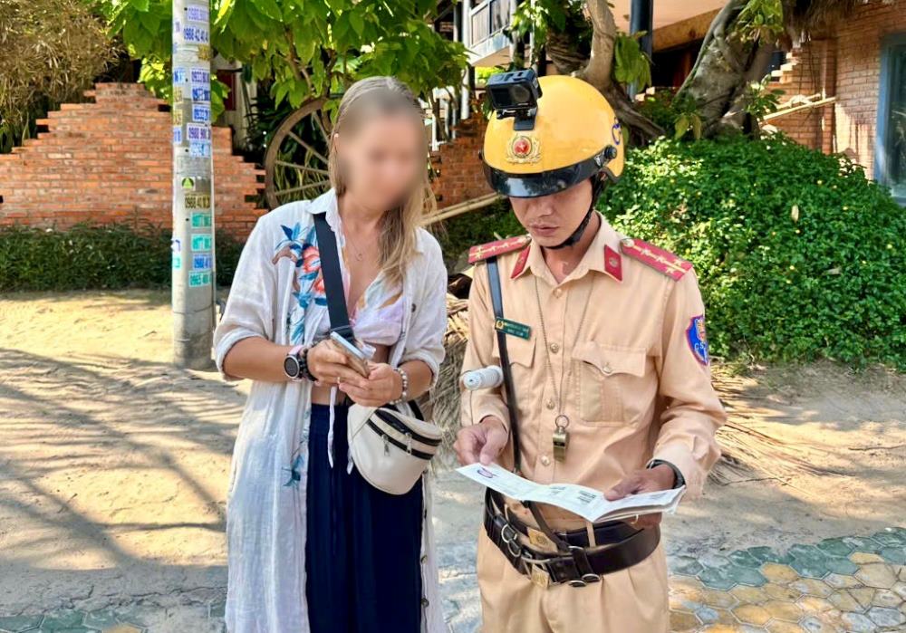 Cảnh sát Giao thông dừng xe, kiểm tra giấy phép lái xe của một người nước ngoài điều khiển xe máy. Ảnh: Duy Tuấn 