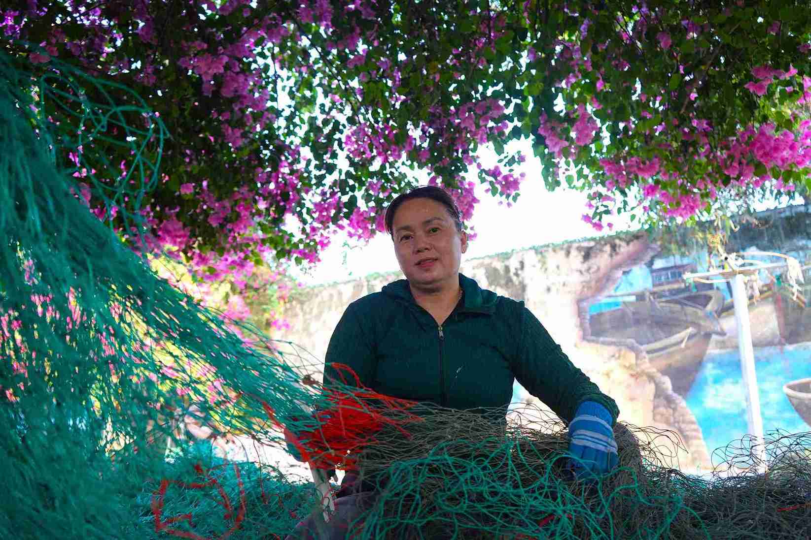 Nhiều người dân tận dụng bóng mát dưới tán cây hoa giấy để mưu sinh. Ảnh: Hữu Long