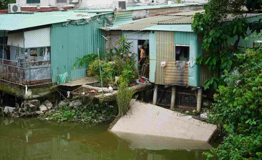 Một phần căn nhà bị sạt lở xuống rạch Giồng Ông Tố (phường Bình Trưng, TPHCM). Ảnh: Minh Quân