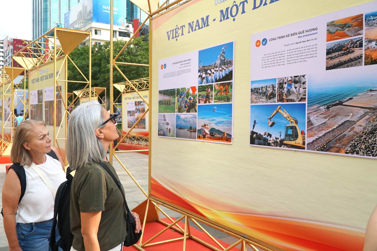 Khách quốc tế xem triển lãm ảnh ở phố đi bộ Nguyễn Huệ. Ảnh: Thanh Chân