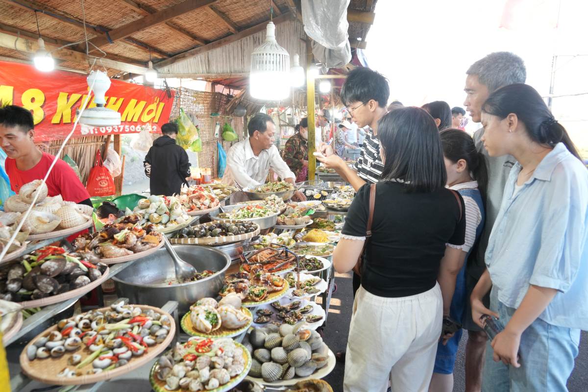 Nhiều món được bày bán tại chợ quê An Nhứt, từ trái cây, bánh đến các món ốc, hải sản. Ảnh: Thành An