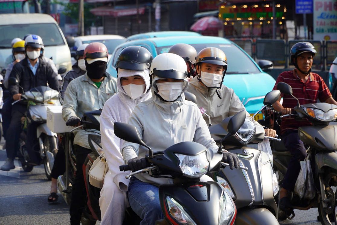Người đi xe máy vất vả di chuyển dưới thời tiết nắng nóng. Ảnh: Nguyên Chân