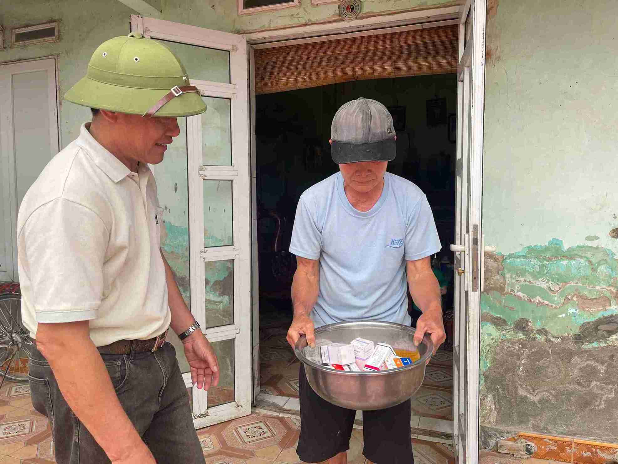 Ông Thạch cầm thau thuốc trên tay, gương mặt mệt mỏi sau những ngày dài chống chọi với bệnh tật. Ảnh: Mai Hương