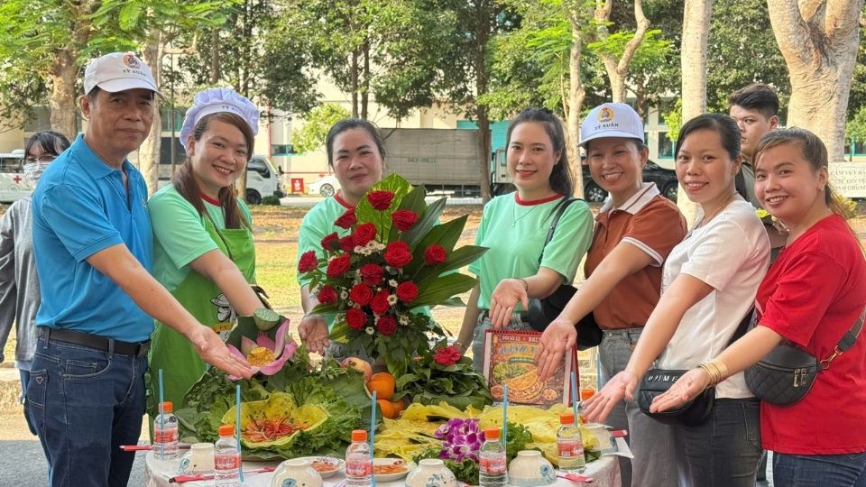 Chairman of the grassroots Trade Union of Ty Xuan Co., Ltd. Le Van Tien (left cover) and the team participating in the cooking contest at the company. Photo: Hoang Loc