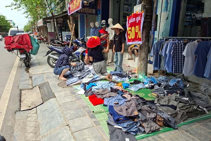 Người dân họp chợ, bày bán quần áo ngay trên vỉa hè, gây mất mỹ quan đô thị. Ảnh: