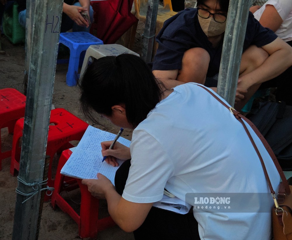 Người dân xếp thành 5 hàng, ghi tên vào sổ để giữ chỗ. Ảnh: Như Hạ