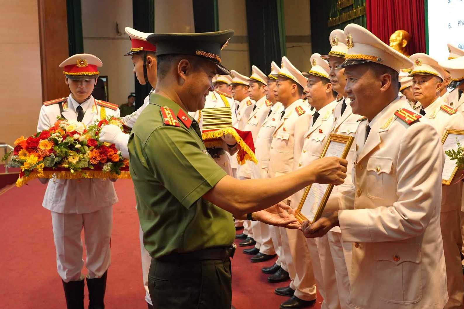 Đại tá Nguyễn Ngọc Quyền, Phó Giám đốc Công an TP Hà Nội trao quyết định thăng cấp bậc hàm Thượng tá với các sĩ quan đủ điều kiện. Ảnh: Công an Hà Nội