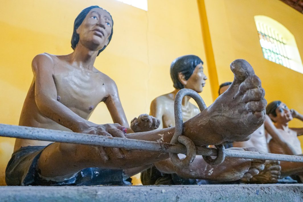 Dưới sự hướng dẫn của thuyết minh viên, học sinh lắng nghe những câu chuyện về thời kỳ các chiến sĩ cách mạng và đồng bào yêu nước bị giam giữ, chịu nhiều gian khổ nhưng vẫn kiên định tinh thần đấu tranh.