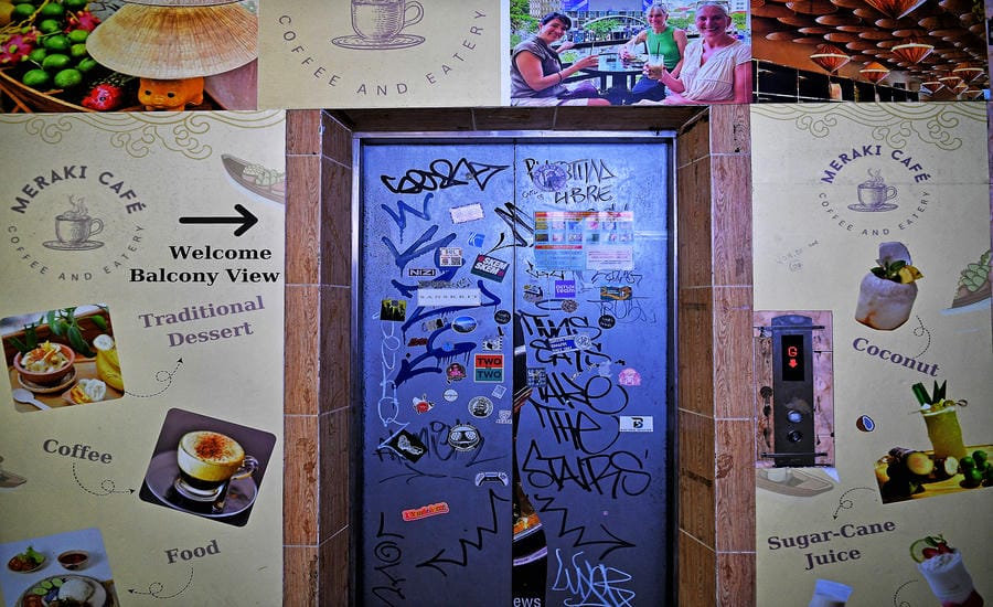 Thang máy cũ nhưng được trang trí bằng poster, typography hiện đại bắt mắt. Ảnh: Việt Văn