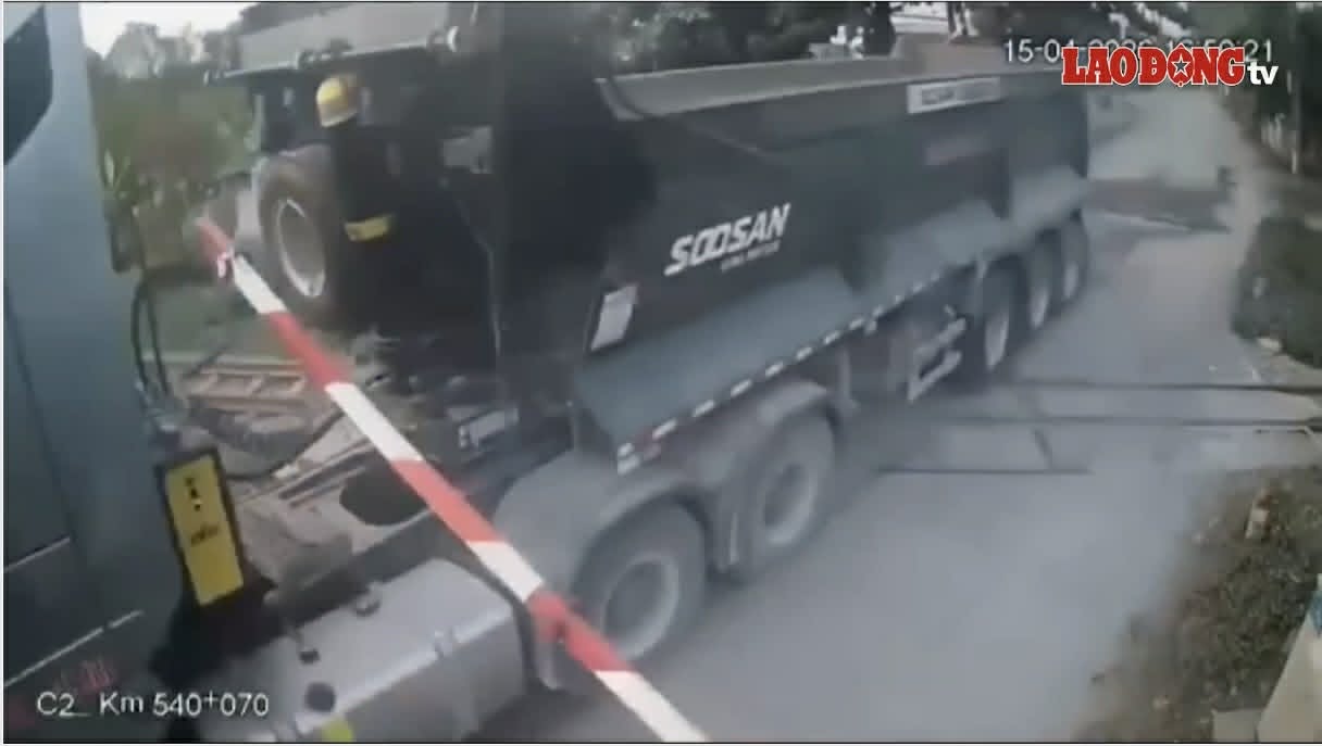 Trailer truck crosses level crossing when train is about to arrive. Photo: cut from clip