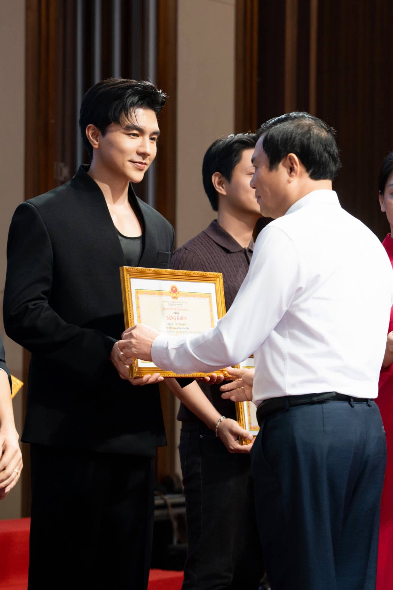 Diễn viên Steven Nguyễn (vai Trung tá Đào Minh Kiên) nhận bằng khen của Bộ trưởng Bộ Quốc phòng. Ảnh Nghệ sĩ cung cấp