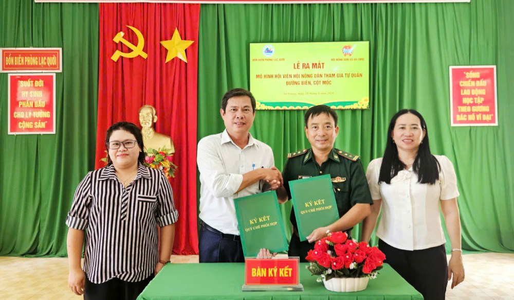 Đồn Biên phòng Lạc Quới và Hội Nông dân xã Ba Chúc ký kết chương trình phối hợp hoạt động và trao quyết định thành lập các Tổ tự quản đường biên. Ảnh: Tiến Vinh
