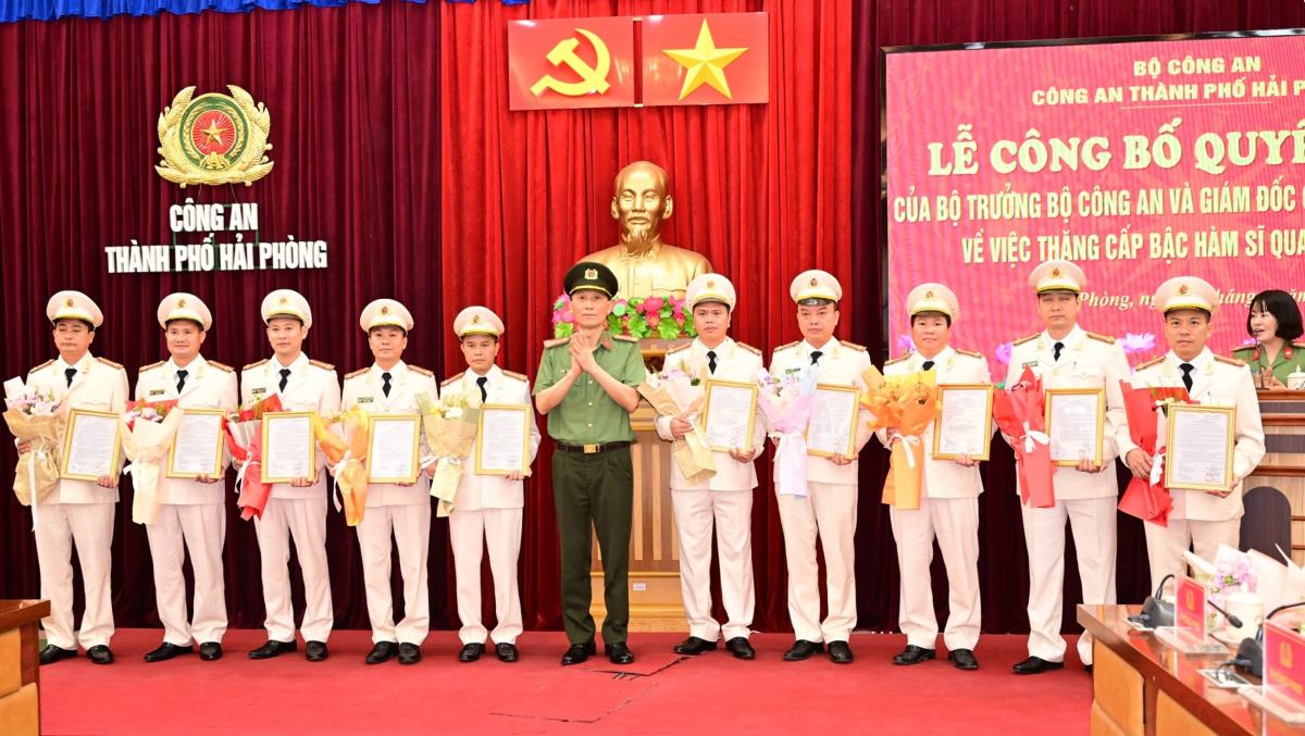 Đại tá Phạm Viết Dũng - Phó Giám đốc Công an thành phố trao quyết định và tặng hoa chúc mừng các Trưởng Công an cấp xã được thăng cấp bậc hàm Thượng tá. Ảnh: Công an Hải Phòng