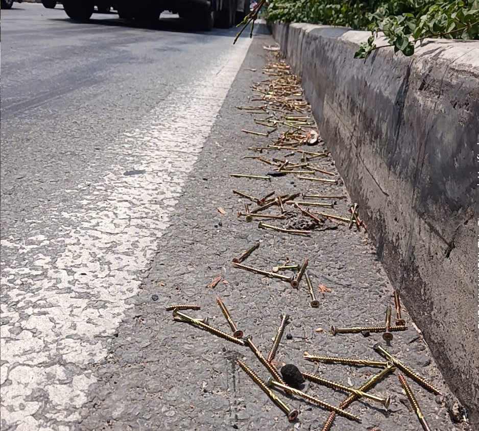 Số đinh vít rơi rải rác trên đường được tài xế gom vào sát con lươn. Ảnh: Bạn đọc cung cấp