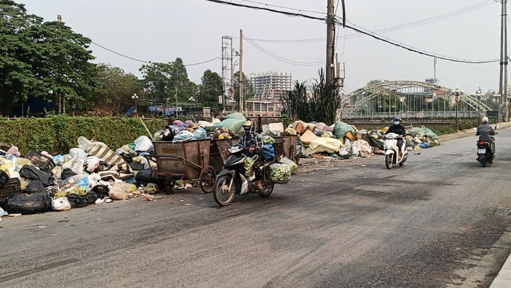 Tại nhiều điểm tập kết, rác thải chất thành từng đống, tràn ra đường và bốc mùi hôi thối, ảnh hưởng đến đời sống, đi lại của người dân. Ảnh: Quách Du