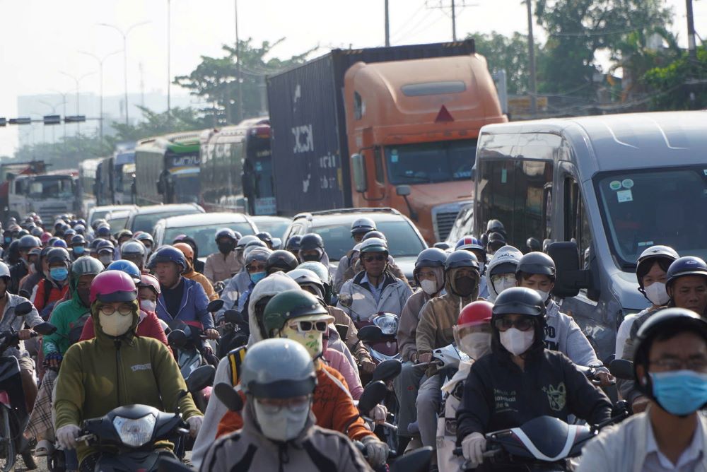 Từ khoảng 7h, dòng xe máy và ôtô đã nối đuôi nhau di chuyển chậm qua khu vực nút giao Bình Thuận. Nhiều thời điểm, các phương tiện gần như “chôn chân“, phải nhích từng chút một. Tiếng còi xe vang lên liên tục, không khí trở nên ngột ngạt khi lượng xe đổ dồn về cùng lúc.