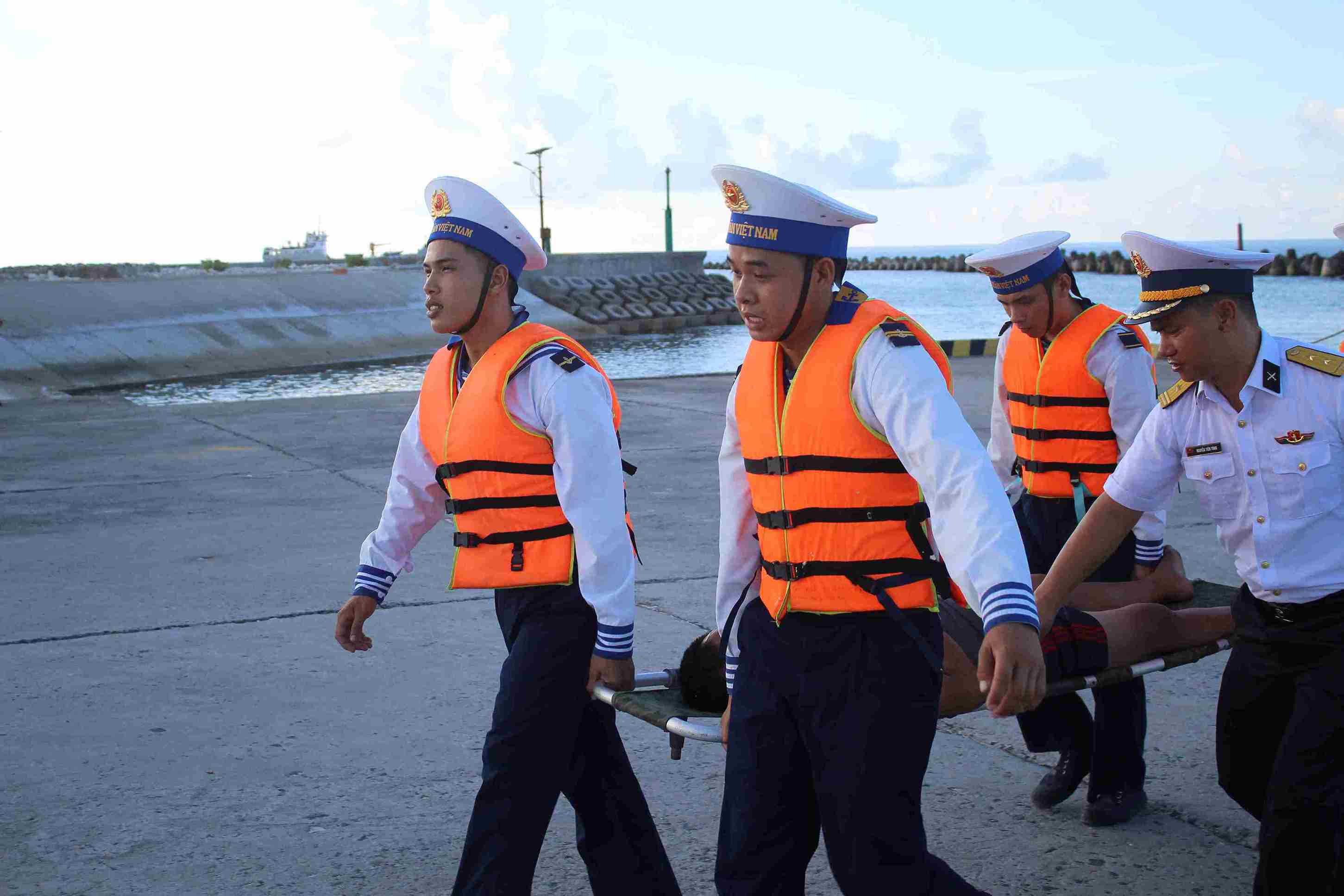 Officers and soldiers of Song Tu Tay island rescue fishermen at the wharf. Photo: Thanh Vu