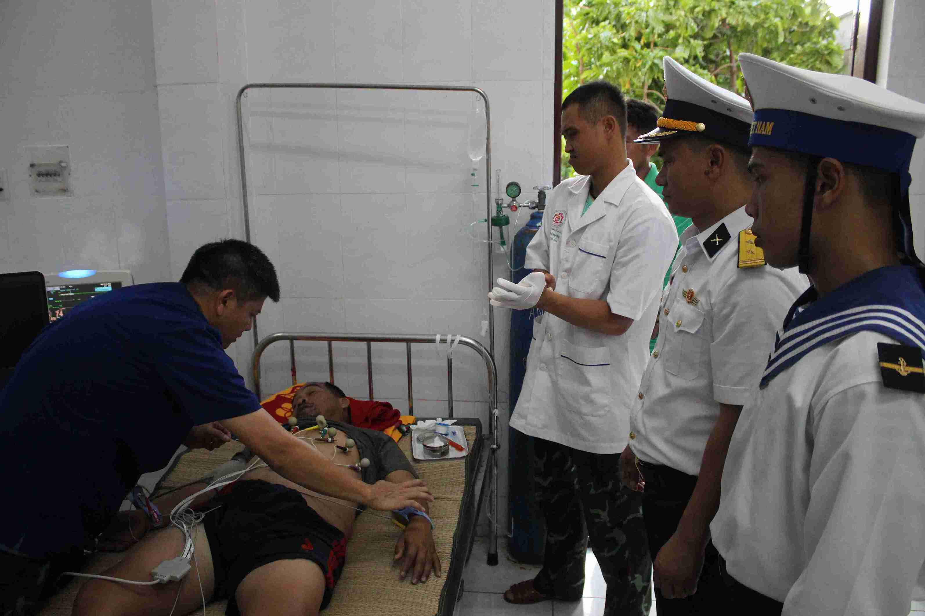 Đội ngũ y bác sĩ thăm khám cho bệnh nhân bằng phương pháp điện tim. Ảnh: Thành Vũ