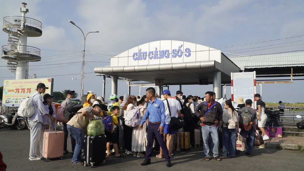 Lực lượng bảo vệ hỗ trợ hướng dẫn hành khách xếp hàng gọn gàng, tránh làm ảnh hưởng ùn tắc giao thông khu vực bến tàu. Ảnh: Nguyên Anh