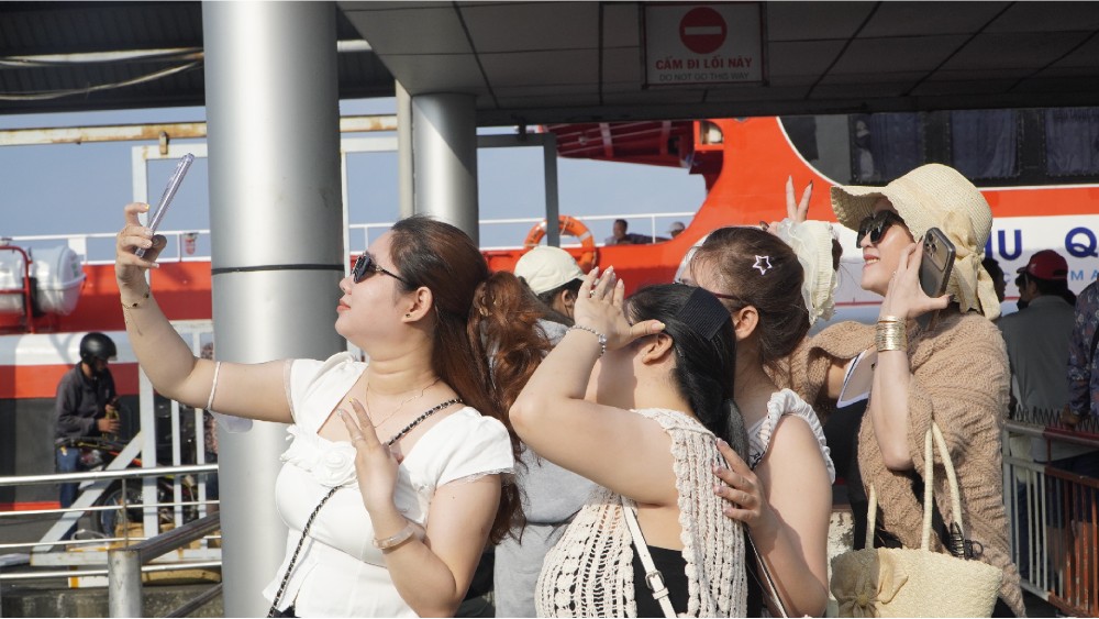 Du khách tranh thủ chụp vài kiểu ảnh check-in tại khu vực bến tàu. Ảnh: Nguyên Anh