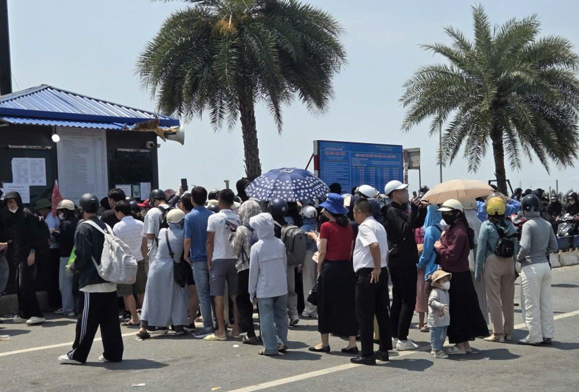 Du khách xếp hàng mua vé qua phà dưới thời tiết nắng, nóng ngày đầu nghỉ lễ. Ảnh: Hoàng Khôi
