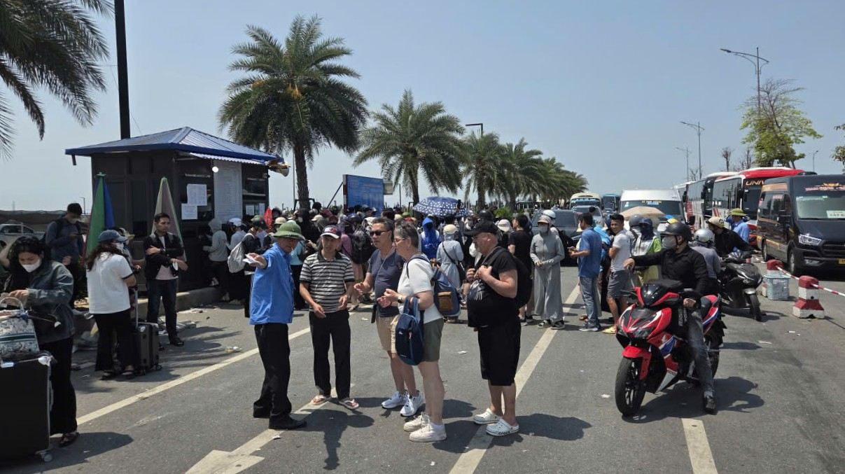 Nhân viên bến phà hướng dẫn khách du lịch nước ngoài di chuyển lên phà. Ảnh: Hoàng Khôi