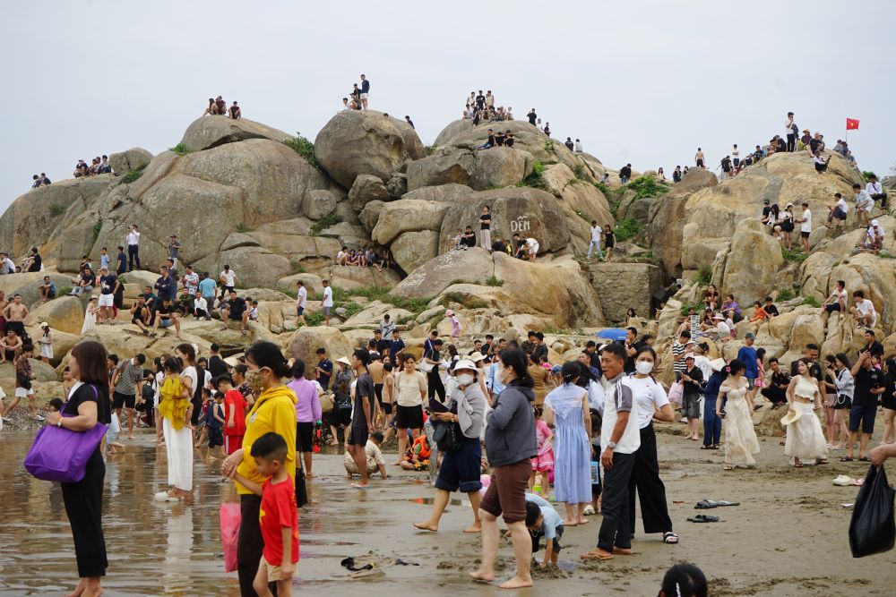 Bãi tắm đông, nhiều người dân, du khách đã tìm đến khu vực mỏm đá (ở bãi tắm A) để ngồi hóng mát. Ảnh: Quách Du
