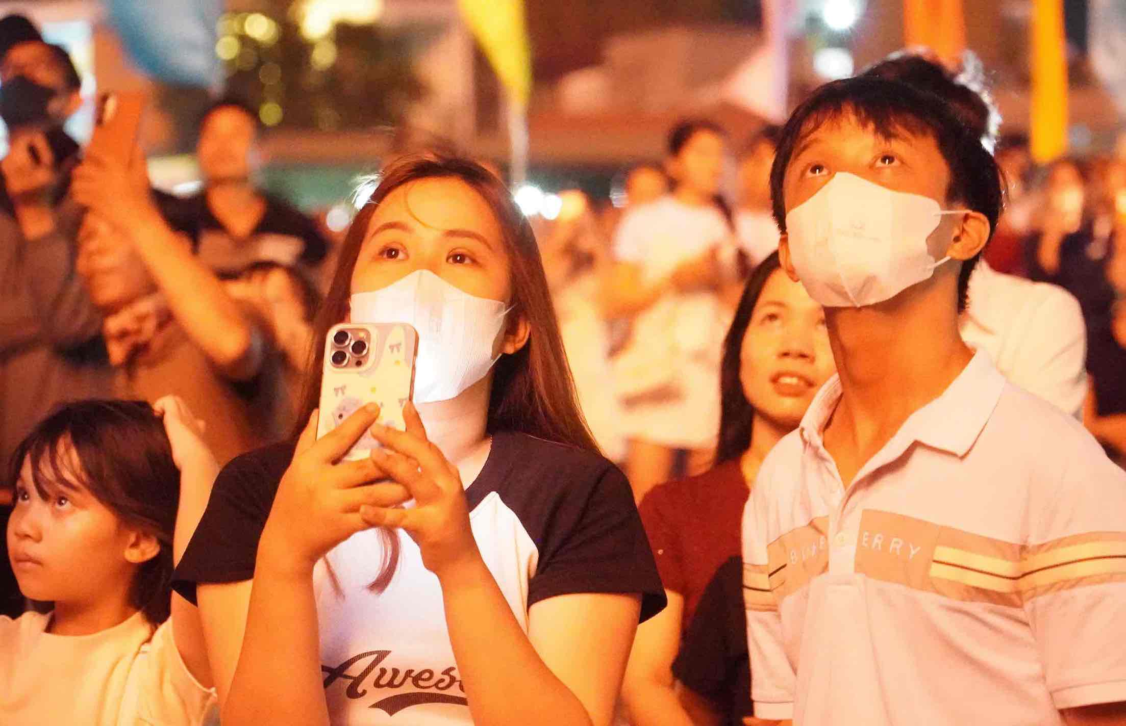 Người dân xem bắn pháo hoa chăm chú, đợt này màn bắn pháo hoa kéo dài 15 phút với nhiều “quả pháo” nổ trên cao đẹp mắt, nổ to khiến người dân liên tục trầm trồ. Ảnh: HAC