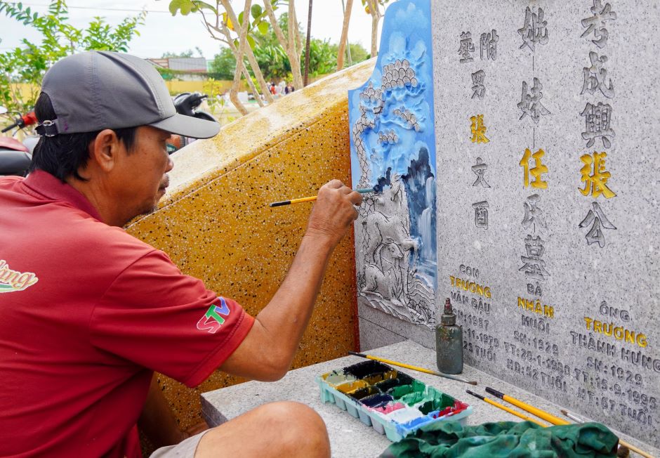 Một bia mộ được sơn, vẽ mới trong dịp Tết Thanh Minh. Ảnh: Phương Anh