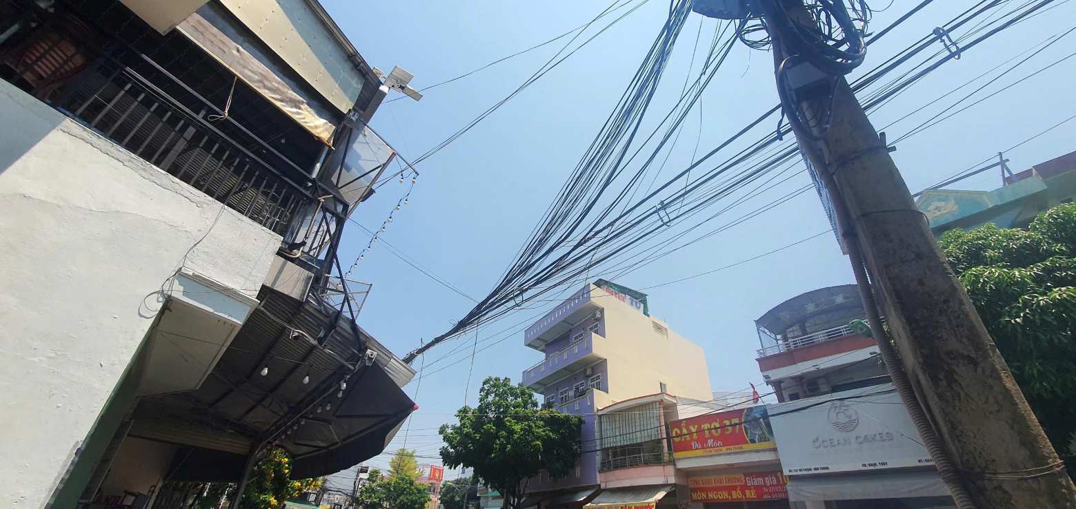 Nạn nhân rơi trúng dây điện trước tòa nhà. Ảnh: Phương Linh