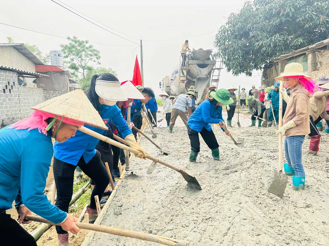 Đoàn viên, thanh niên phường Nghĩa Lộ tham gia san gạt, đổ bê tông tuyến đường nông thôn. 