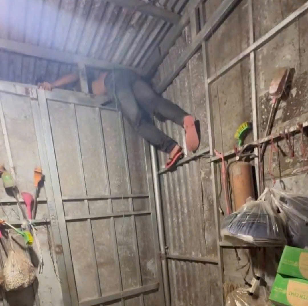 Trung thực nghiệm lại hiện trường đột nhập tiệm tạp hóa trộm cắp từ khe hở hẹp trên mái nhà. Ảnh: Công an cung cấp