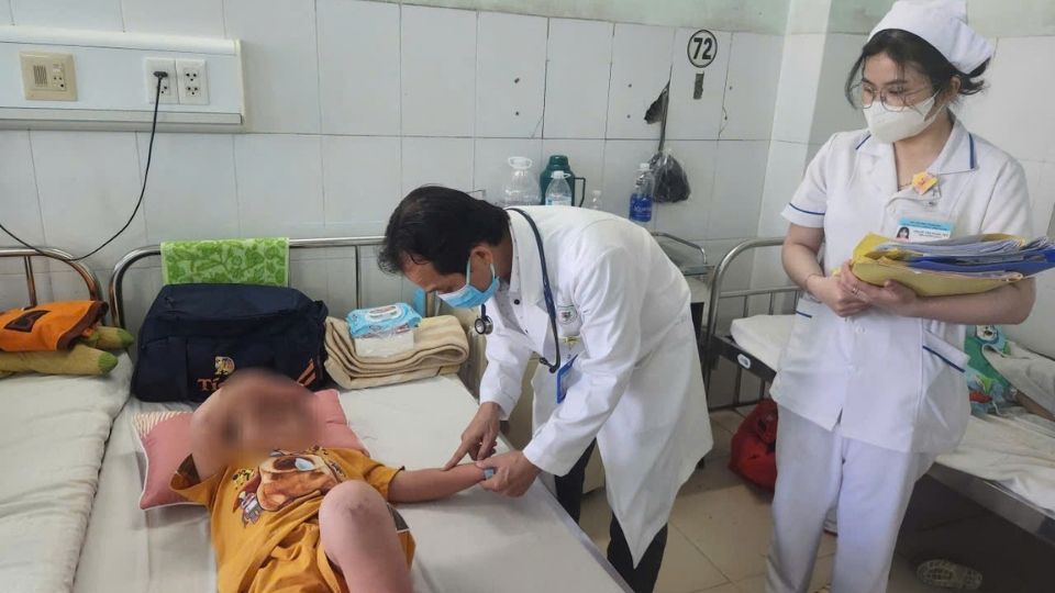 Bác sĩ kiểm tra các nốt đỏ trên tay trẻ nghi mắc tay chân miệng. Ảnh: Hoàng Lộc