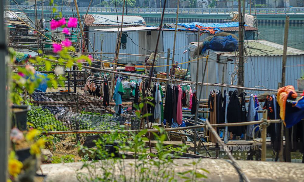 Quần áo được phơi dọc theo các khung tre, phản ánh nhịp sống thường nhật của người dân ven sông.