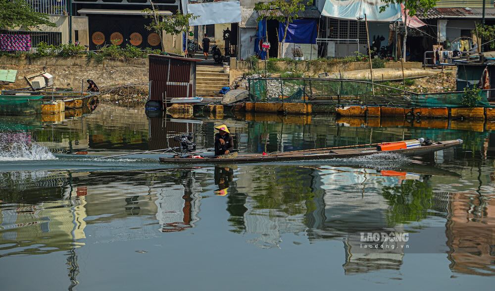 Người dân điều khiển thuyền nhỏ di chuyển trên sông Như Ý phương tiện gắn liền với hoạt động mưu sinh.