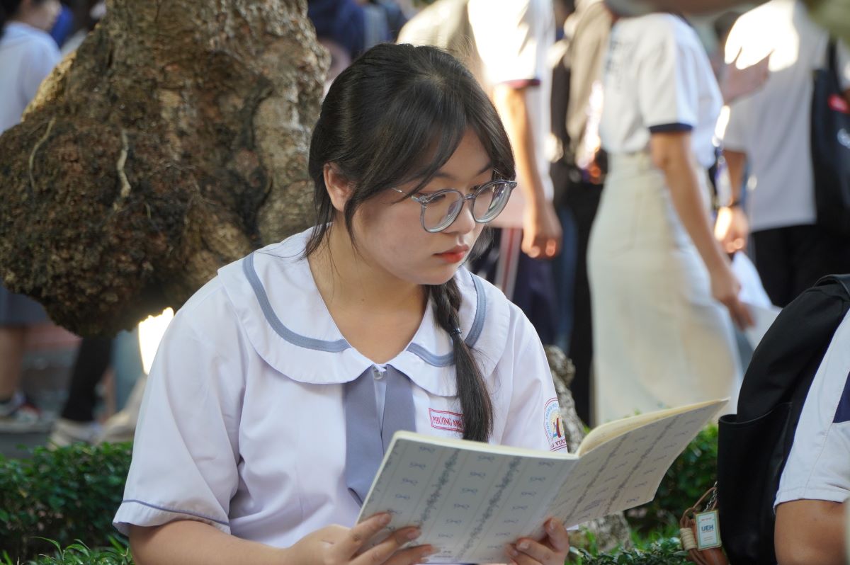 Thí sinh tranh thủ ôn bài trước lúc vào phòng thi. Ảnh: Chân Phúc
