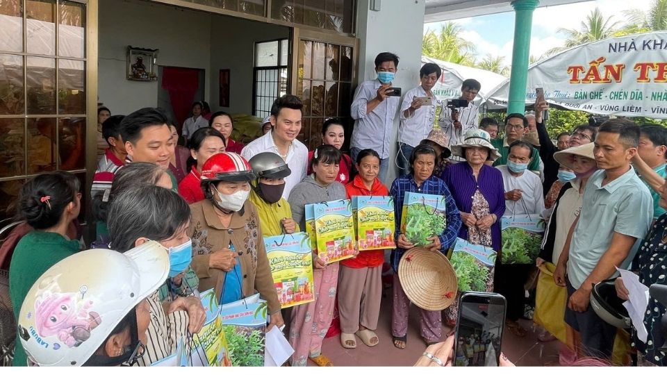 Meritorious Artist Kim Tieu Long and artists present gifts and share with people in difficult circumstances in Quoi A commune. Photo: Hoang Loc