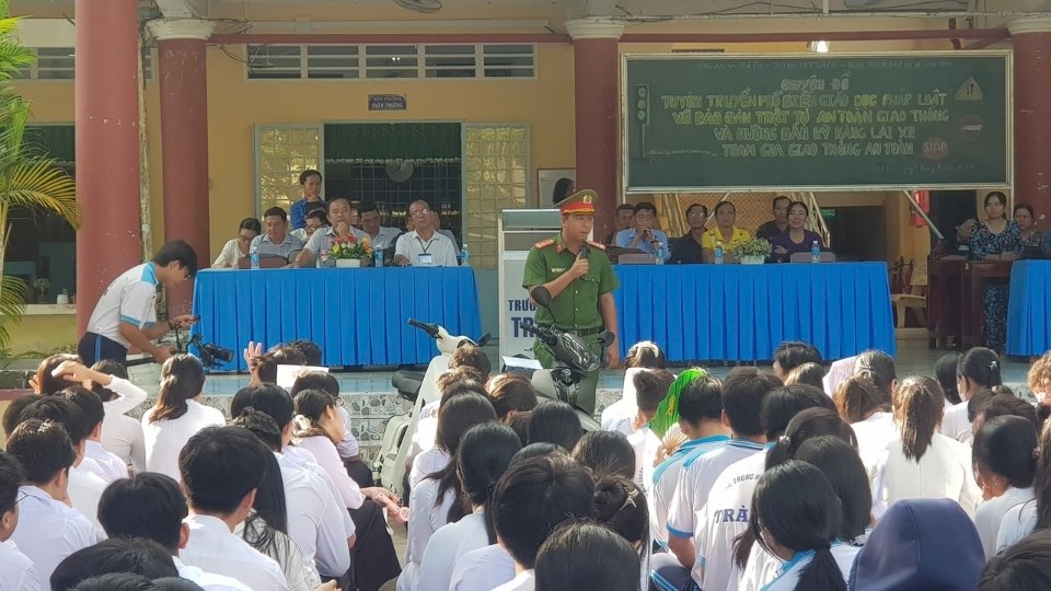 Tra On Commune Police propagate laws on traffic safety and order, and guide students on safe traffic participation skills. Photo: Hoang Loc