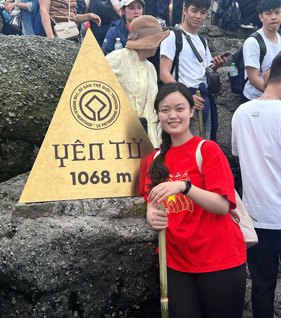 Thanh Huyền chụp hình kỷ niệm cùng cột mốc trên đỉnh núi Yên Tử. Ảnh: NVCC