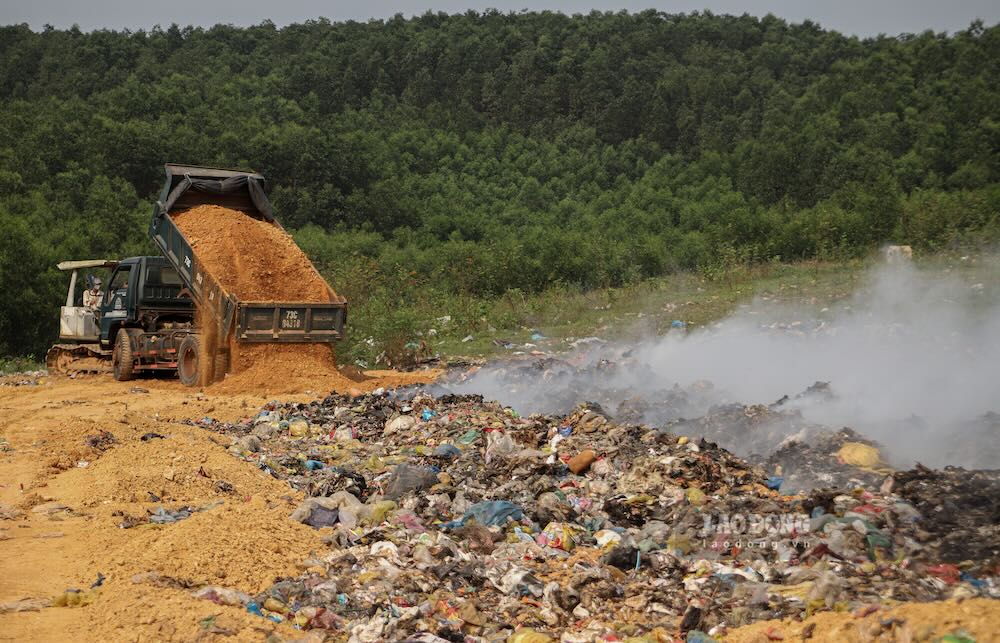 Truck carrying soil into the landfill to put out the fire. Photo: Nguyen Luan