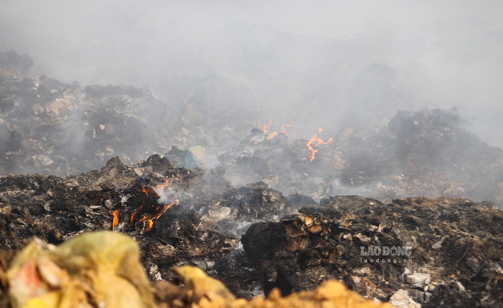 Lớp rác dày, cháy đều khiến công tác dập lửa gặp khó khăn. Ảnh: Nguyễn Luân