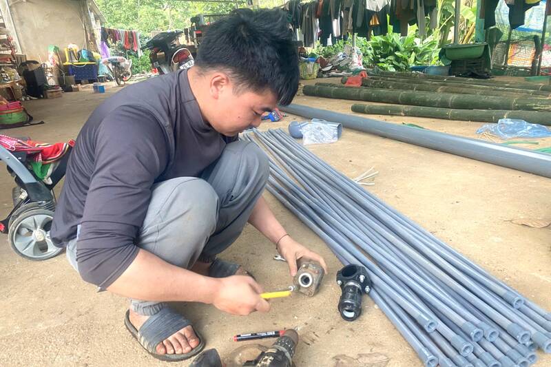 Người dân bản Muông Yên, phường Chiềng Cơi làm ống tưới văng cung cấp nước chủ động cho cây cà phê. Ảnh: Trường Sơn